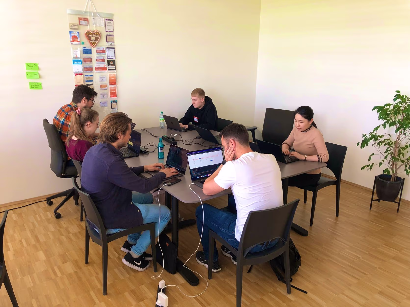 Bild eines Teams, das am Tisch sitzt arbeitet