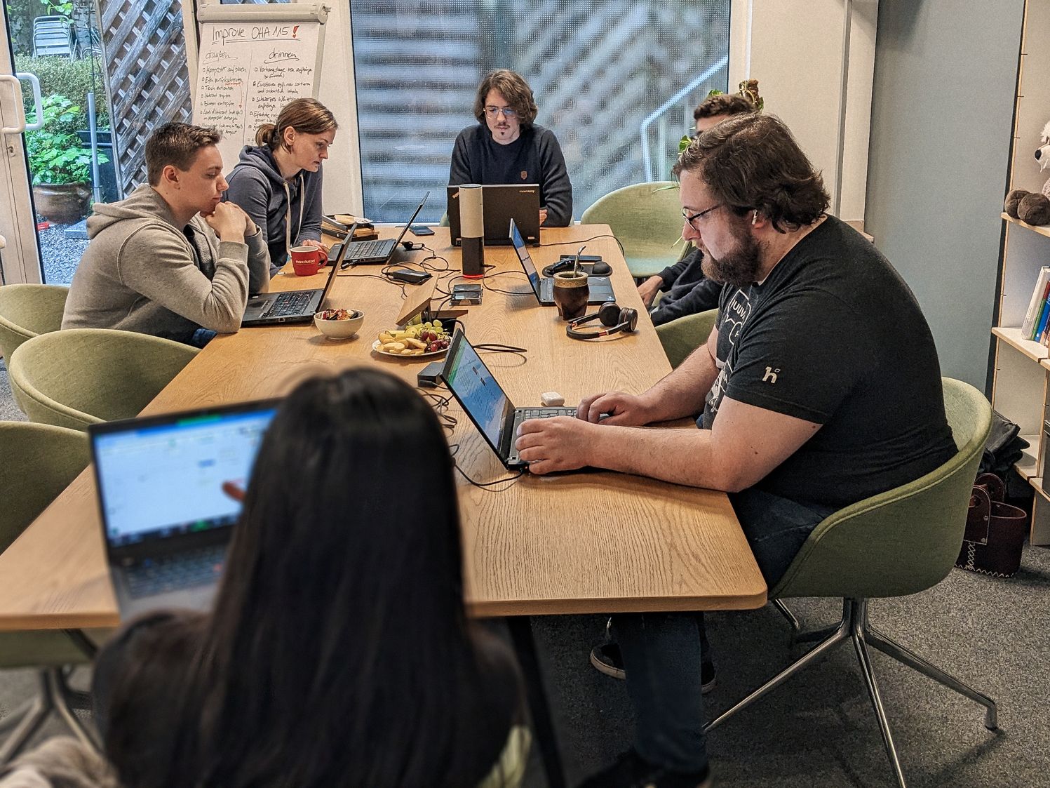 Kollegen sitzen an einem Tisch und arbeiten an Laptops